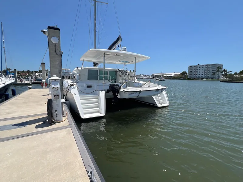 Slide: The Image of 2008 Lagoon 420 catamaran docked at marina under clear blue sky. - 11