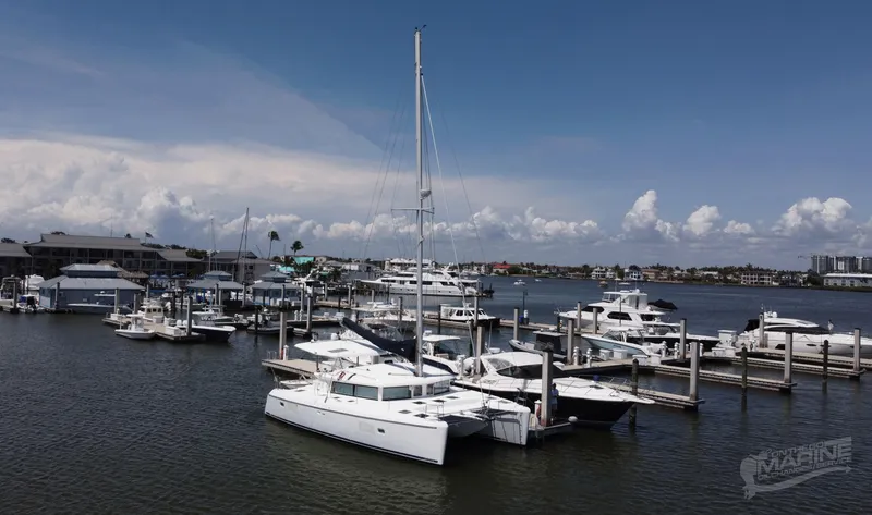 Slide: The Image of Lagoon 420 catamaran docked at a marina, 2008 model, under a clear blue sky. - 2