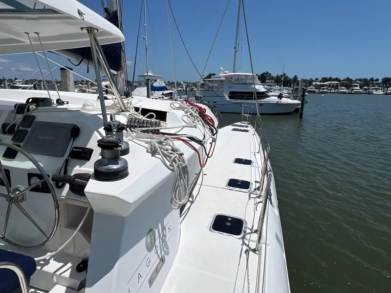 Slide: The Image of 2008 Lagoon 420 catamaran docked in a marina under clear blue skies. - 27