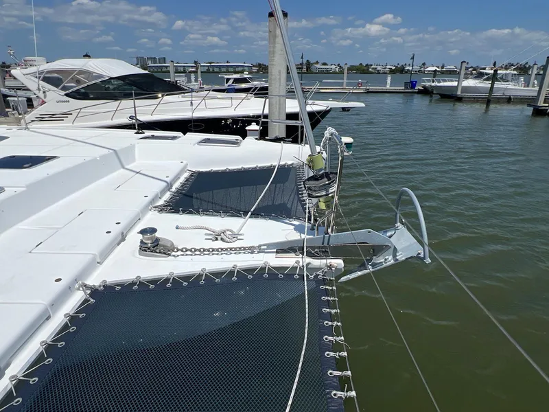 Slide: The Image of 2008 Lagoon 420 catamaran docked at marina, featuring spacious deck and netting. - 38