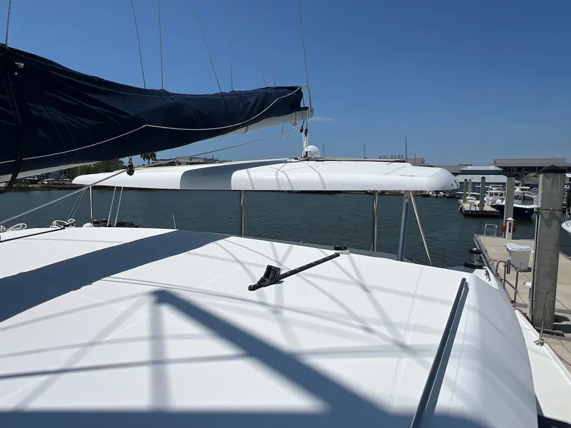 Slide: The Image of 2008 Lagoon 420 catamaran docked at a marina under clear blue skies. - 44