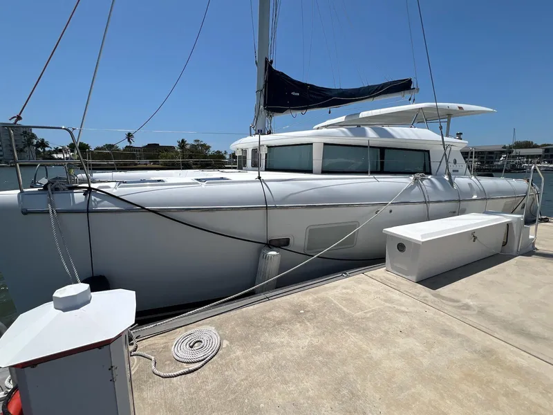 Slide: The Image of 2008 Lagoon 420 catamaran docked at marina under clear blue sky. - 6