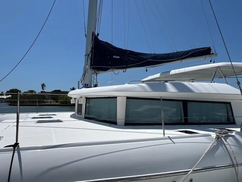 Slide: The Image of 2008 Lagoon 420 catamaran with sails, docked under clear blue sky. - 7