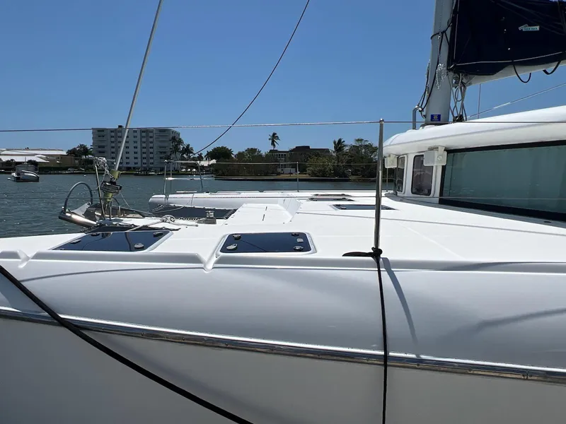 Slide: The Image of 2008 Lagoon 420 catamaran docked in a sunny marina setting. - 8