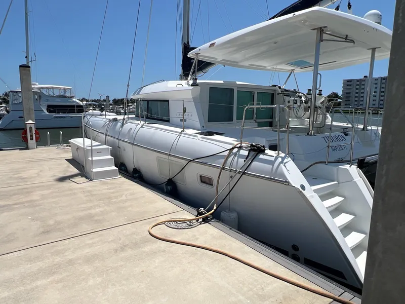 Slide: The Image of 2008 Lagoon 420 catamaran docked at marina, side view with clear sky. - 9