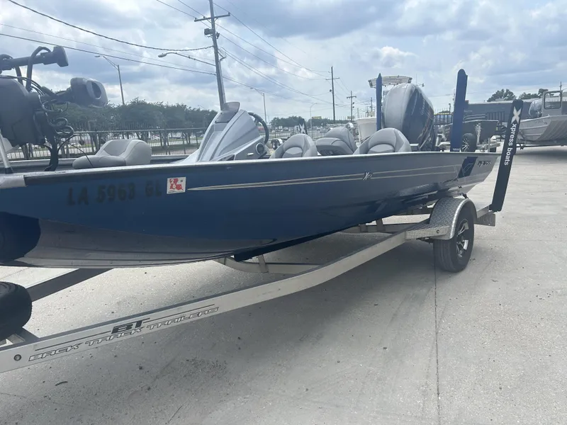 Slide: The Image of 2021 Xpress X19 Pro boat on trailer, parked outdoors under cloudy sky. - 12