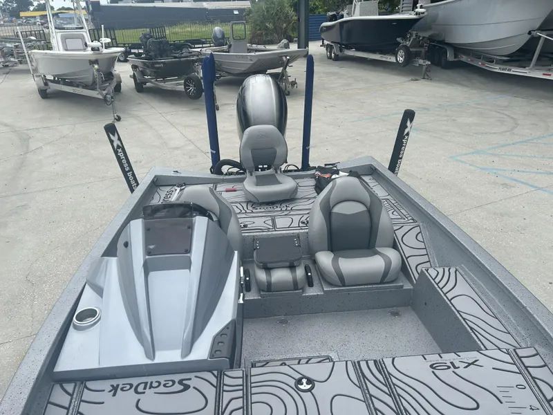 Slide: The Image of 2021 Xpress X19 Pro boat with sleek interior design, parked among other boats. - 13