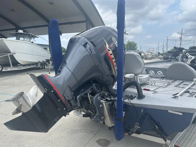 Slide: The Image of 2021 Xpress X19 Pro boat with Yamaha outboard motor, parked under a canopy. - 16