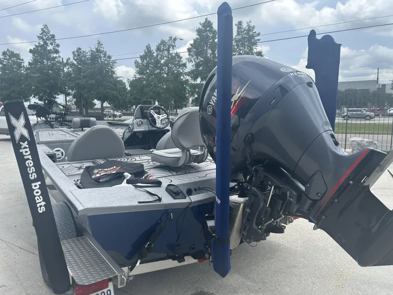 Slide: The Image of 2021 Xpress X19 Pro boat with Yamaha engine, parked outdoors under cloudy sky. - 7