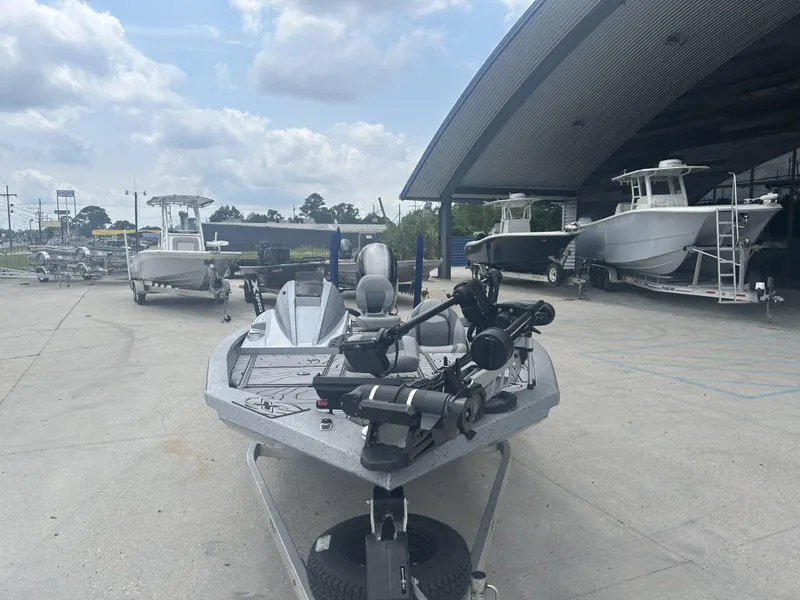 Slide: The Image of 2021 Xpress X19 Pro boat displayed outdoors near other boats and trailers. - 9