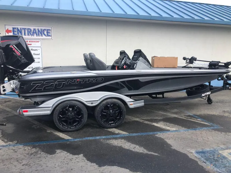 Slide: The Image of 2020 Nitro Z20 boat on trailer, parked outside a building with blue roof. - 0
