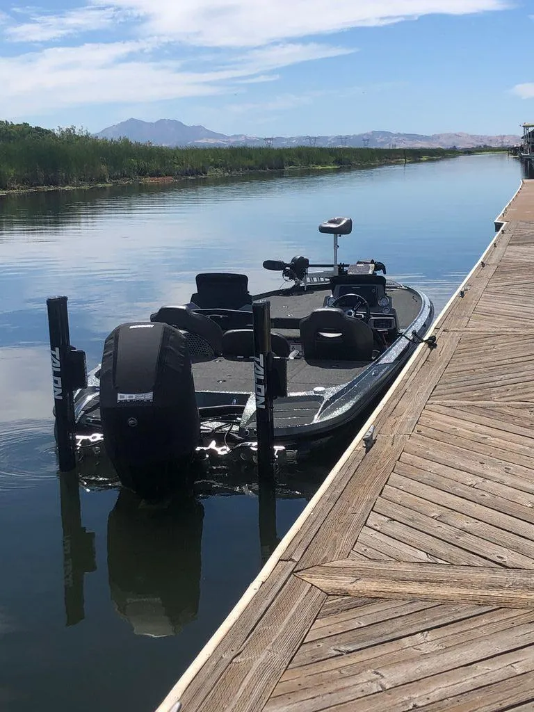 Slide: The Image of 2020 Nitro Z20 boat docked on a calm lake with scenic mountain views. - 10