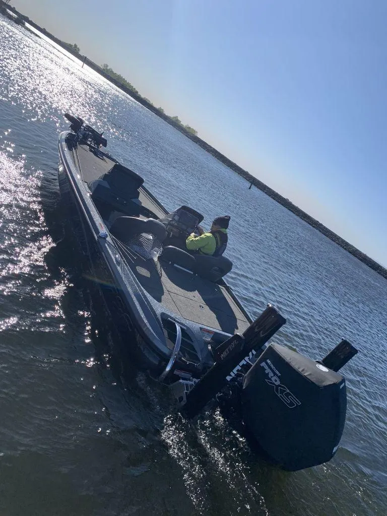 Slide: The Image of 2020 Nitro Z20 boat on water, person seated, sunny day, sparkling reflections. - 13