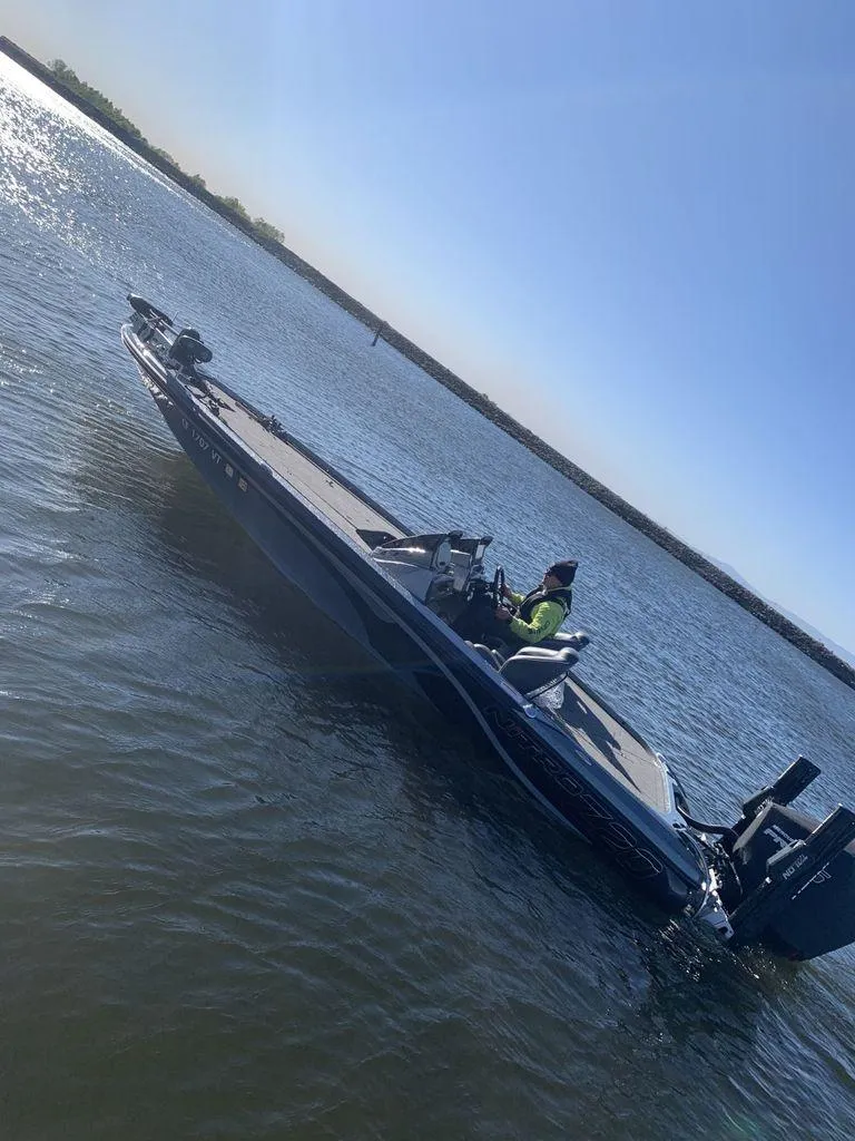Slide: The Image of 2020 Nitro Z20 boat on a sunny lake, with a person steering. - 14