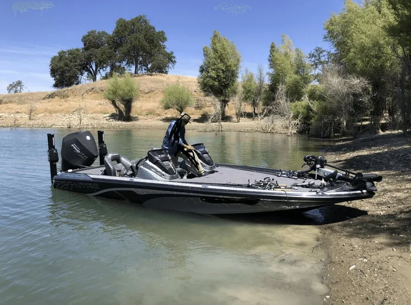 Slide: The Image of 2020 Nitro Z20 boat docked by a serene lakeside with trees in the background. - 15