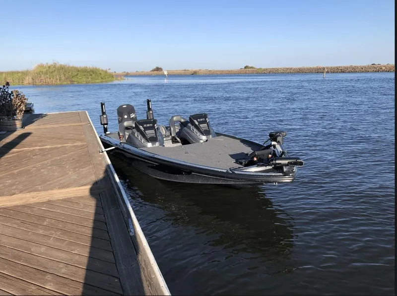 Slide: The Image of 2020 Nitro Z20 boat docked on calm water under clear blue sky. - 8