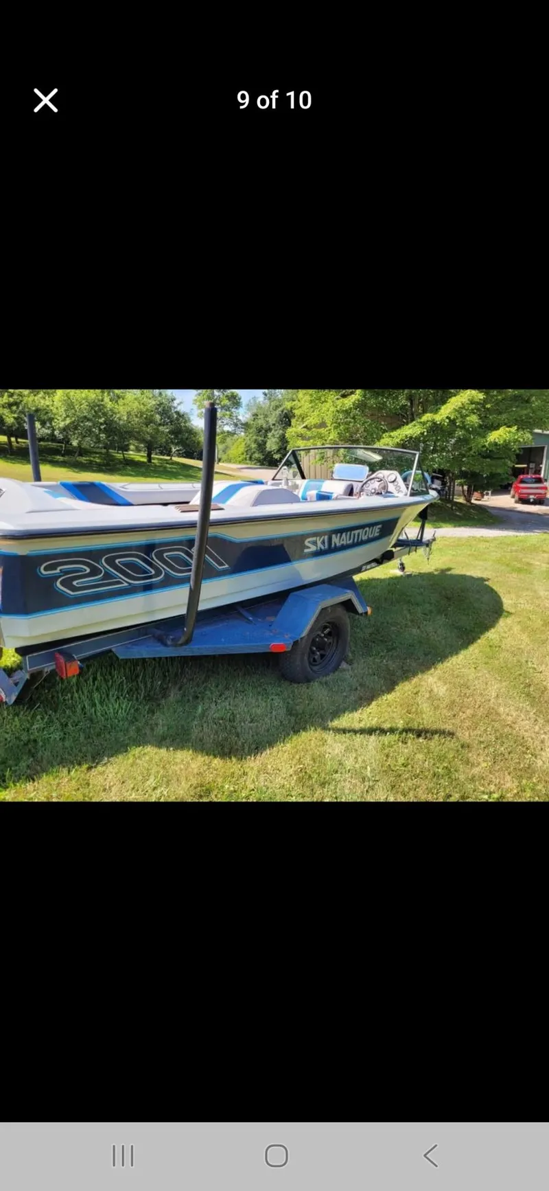 Slide: The Image of 1986 Correct Craft Ski Nautique boat on trailer, parked on grass. - 2