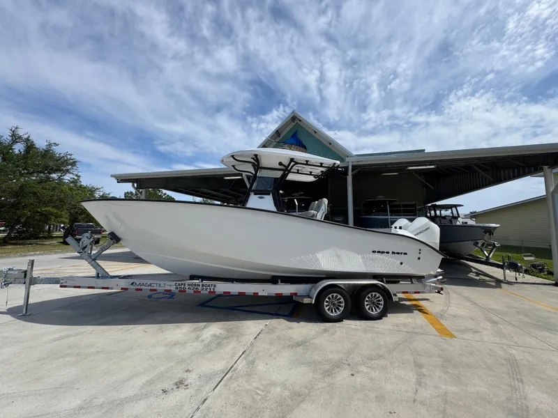Slide: The Image of 2025 Cape Horn 27 XS boat on trailer, parked outdoors under a cloudy sky. - 1