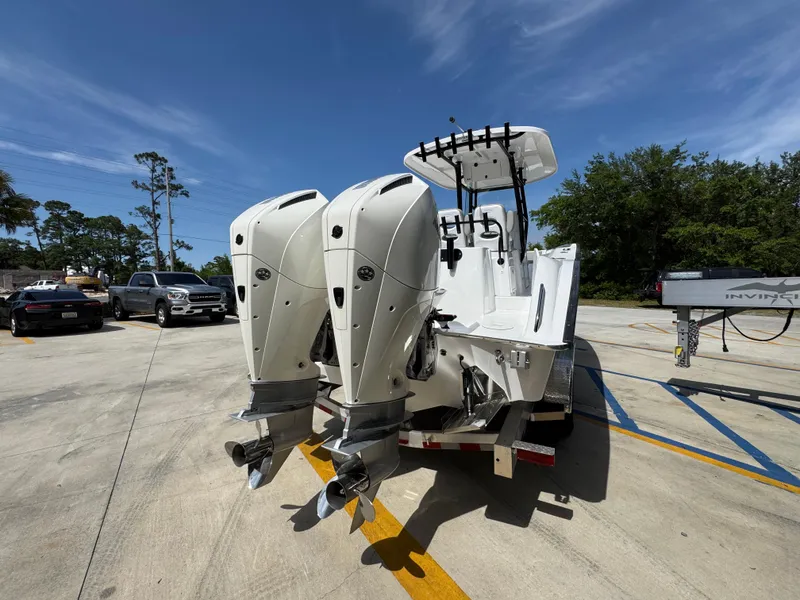 Slide: The Image of 2025 Cape Horn 27 XS boat with dual outboard motors in a sunny parking lot. - 11