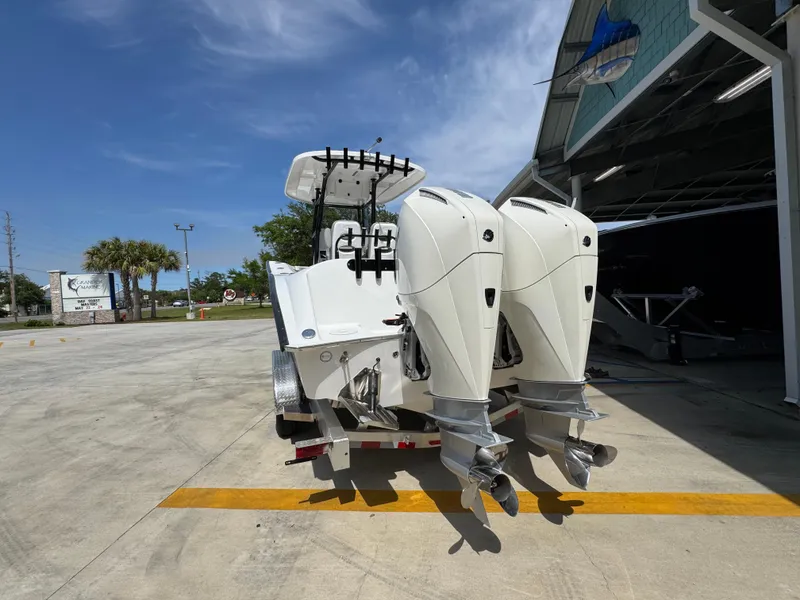 Slide: The Image of 2025 Cape Horn 27 XS boat with dual outboard engines in a sunny marina. - 14