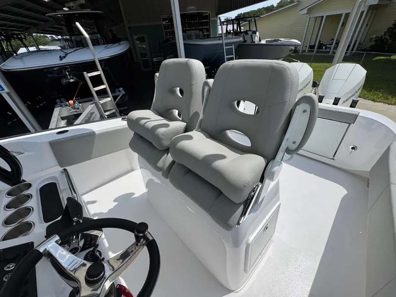Slide: The Image of 2025 Cape Horn 27 XS boat interior with dual cushioned seats and steering wheel. - 31
