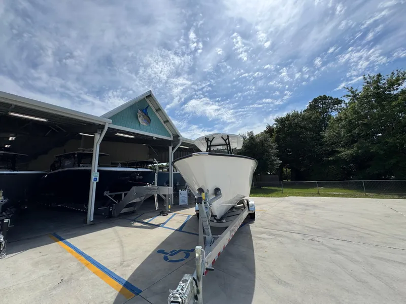 Slide: The Image of 2025 Cape Horn 27 XS boat on trailer outside a storage facility under a partly cloudy sky. - 6