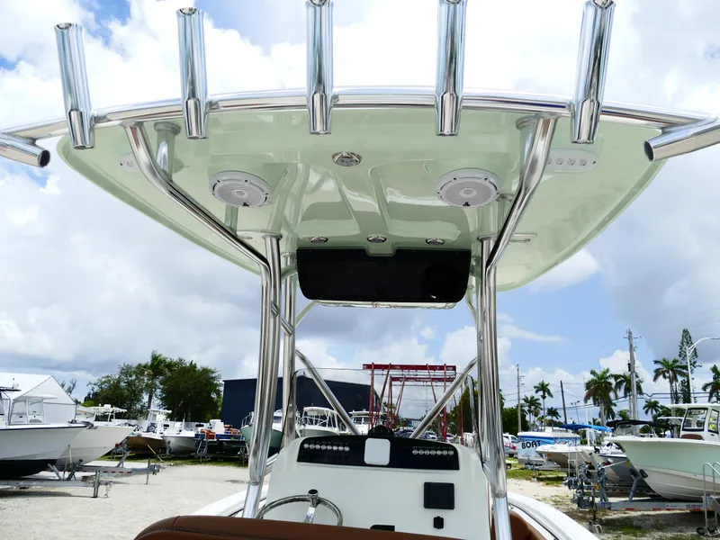 Slide: The Image of 2026 Pioneer 222 Islander boat with T-top and rod holders, displayed outdoors. - 12