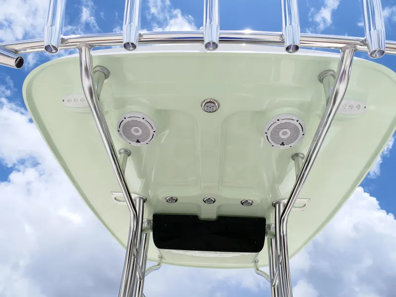 Slide: The Image of 2026 Pioneer 222 Islander boat T-top with speakers and rod holders against blue sky. - 18