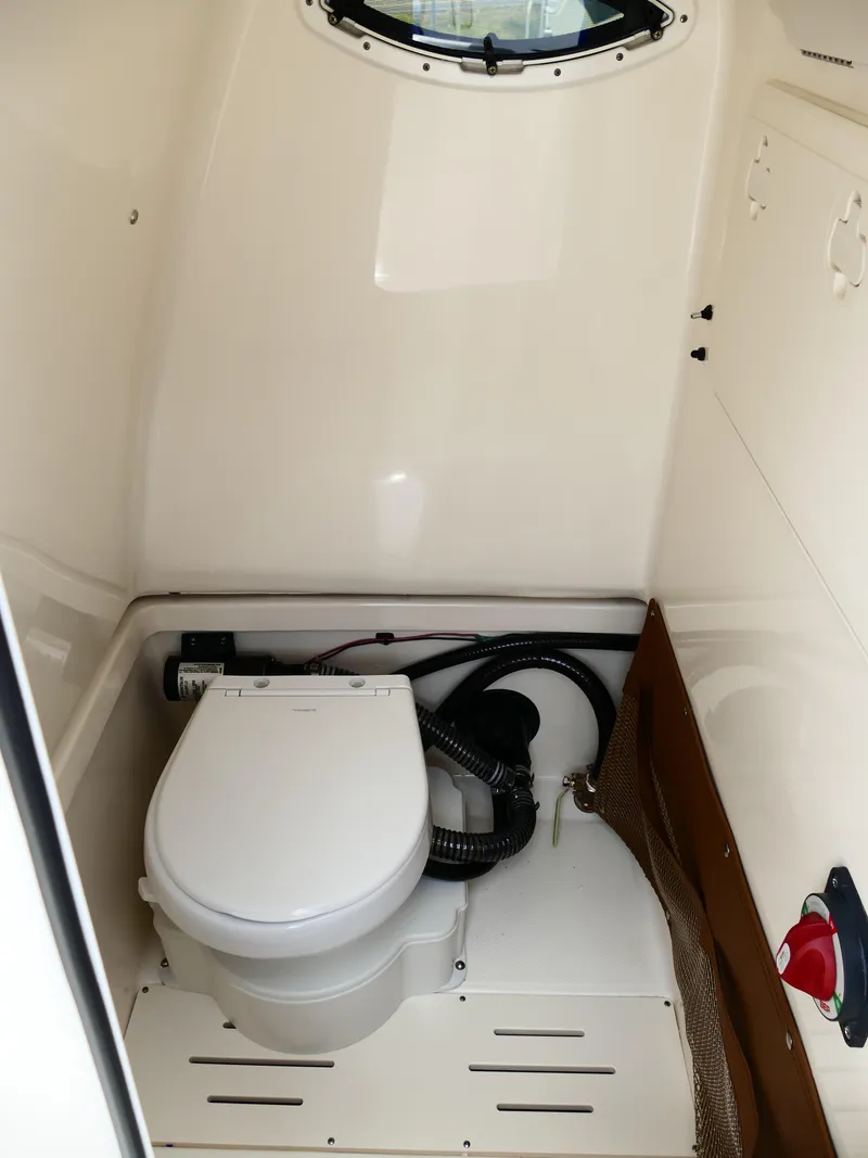 Slide: The Image of 2026 Pioneer 222 Islander boat interior with compact marine toilet. - 34