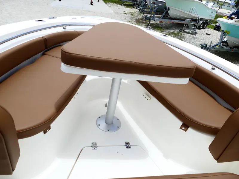 Slide: The Image of 2026 Pioneer 222 Islander boat interior with brown cushioned seating and table. - 37