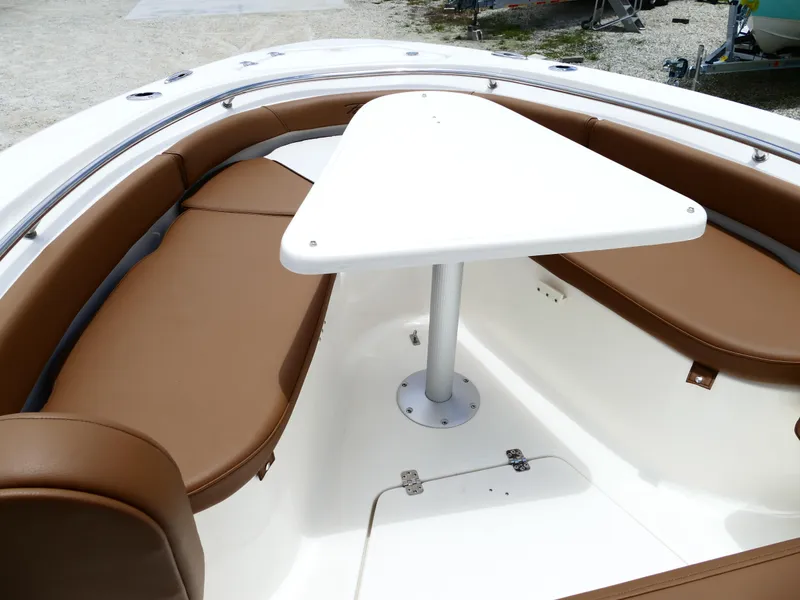 Slide: The Image of 2026 Pioneer 222 Islander boat interior with brown seating and white table. - 38