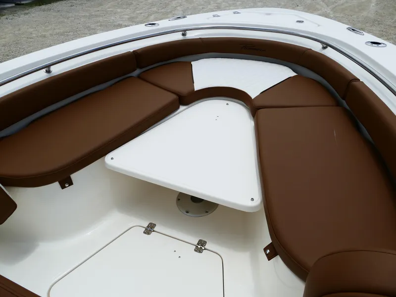 Slide: The Image of 2026 Pioneer 222 Islander boat interior with brown seating and white table. - 39