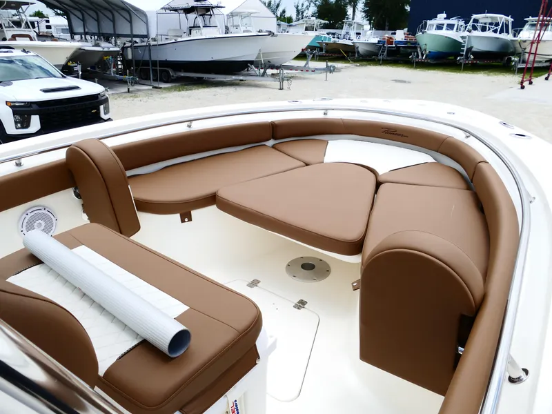 Slide: The Image of 2026 Pioneer 222 Islander boat interior with brown cushioned seating and white accents. - 40