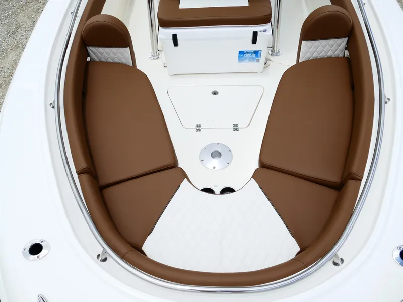 Slide: The Image of 2026 Pioneer 222 Islander boat interior with brown cushioned seating and white flooring. - 44