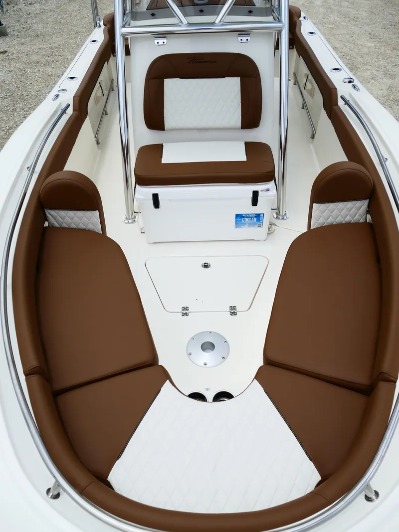 Slide: The Image of 2026 Pioneer 222 Islander boat interior with brown and white cushioned seating. - 45