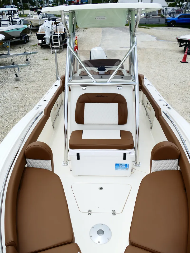 Slide: The Image of 2026 Pioneer 222 Islander boat interior with brown seating and white accents. - 46