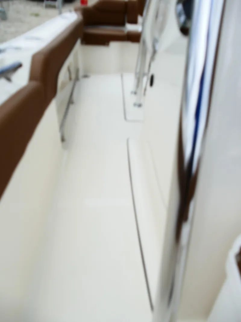 Slide: The Image of 2026 Pioneer 222 Islander boat interior with brown seating and sleek design. - 49