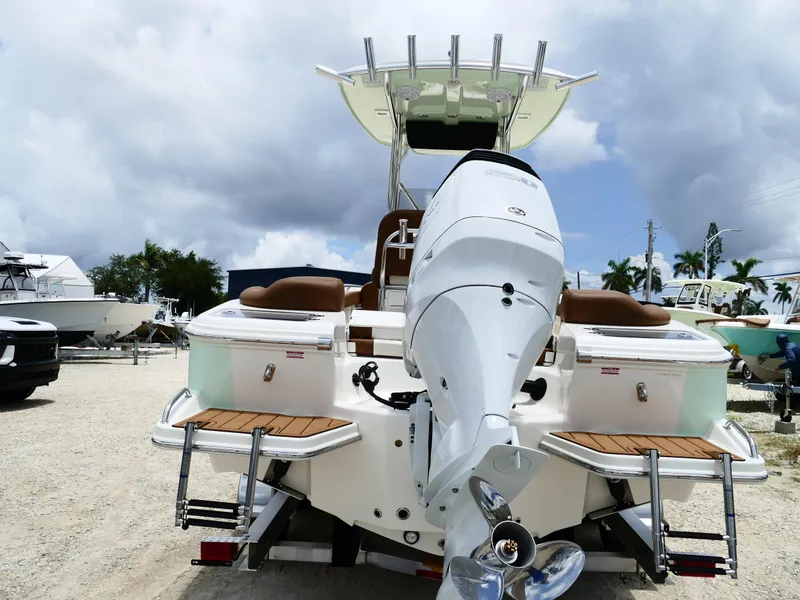 Slide: The Image of 2026 Pioneer 222 Islander boat with outboard motor, docked under cloudy sky. - 7
