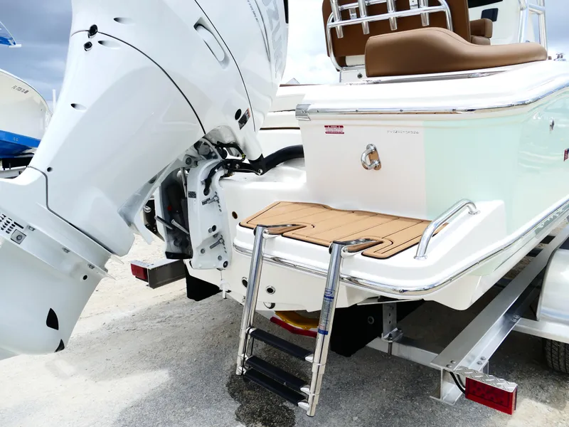 Slide: The Image of 2026 Pioneer 222 Islander boat with outboard motor and swim ladder on trailer. - 9