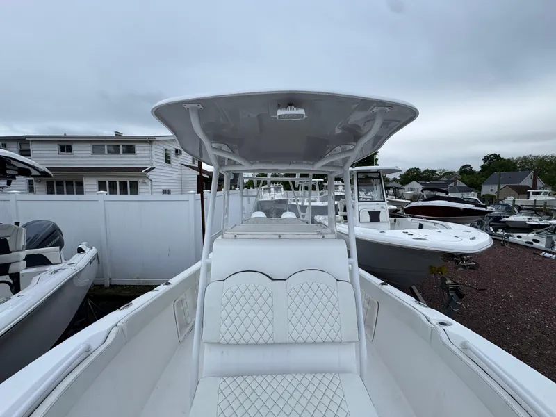 Slide: The Image of 2024 Clearwater 2500 boat with white seating and T-top in a marina setting. - 10