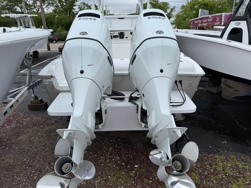 Slide: The Image of Twin outboard engines on a 2024 Clearwater 2500 boat, parked on gravel. - 16