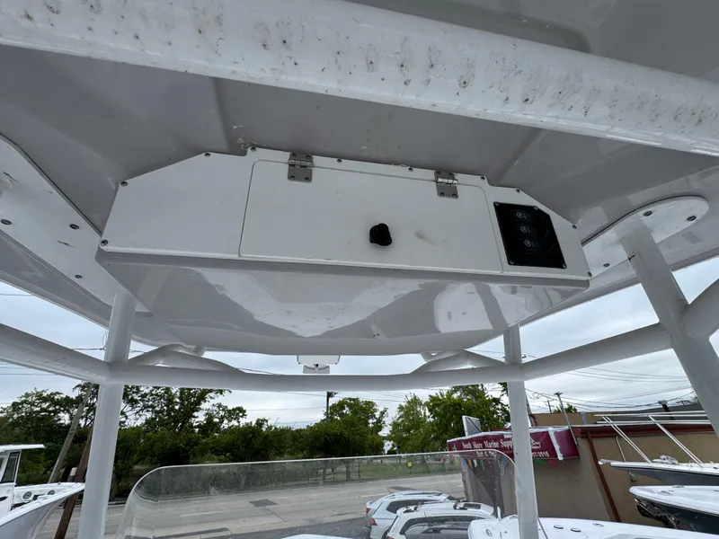 Slide: The Image of 2024 Clearwater 2500 boat's overhead console with storage compartment and controls. - 19