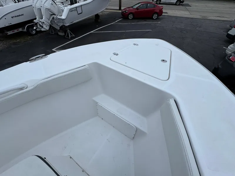 Slide: The Image of 2024 Clearwater 2500 boat bow with seating and storage, parked in a lot. - 6