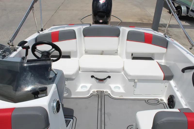 Slide: The Image of 2023 Tahoe T18 boat interior with gray and red seating, steering wheel, and dashboard. - 10