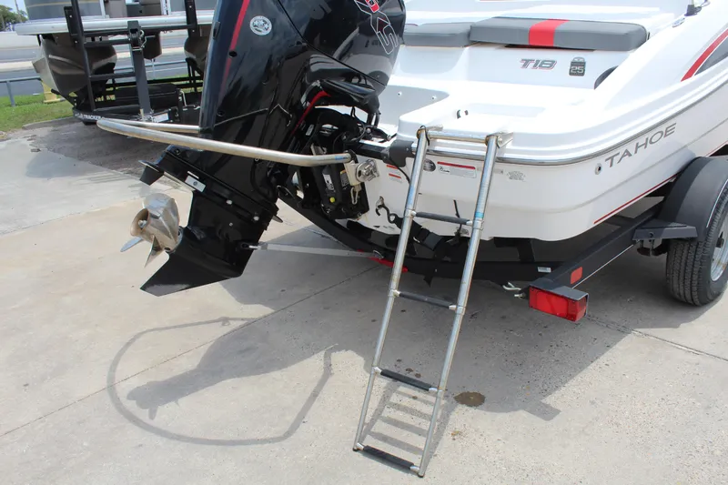Slide: The Image of 2023 Tahoe T18 boat with outboard motor and ladder on trailer. - 18