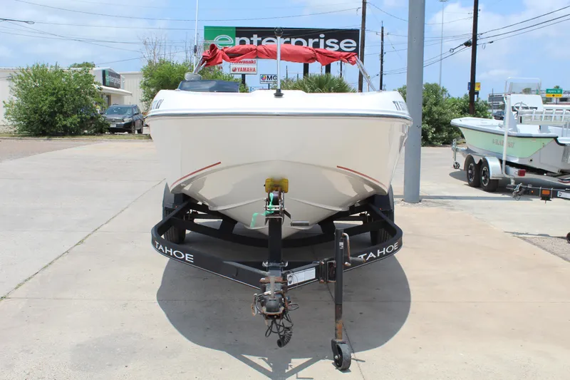 Slide: The Image of 2023 Tahoe T18 boat on trailer, parked outdoors near Enterprise sign. - 2