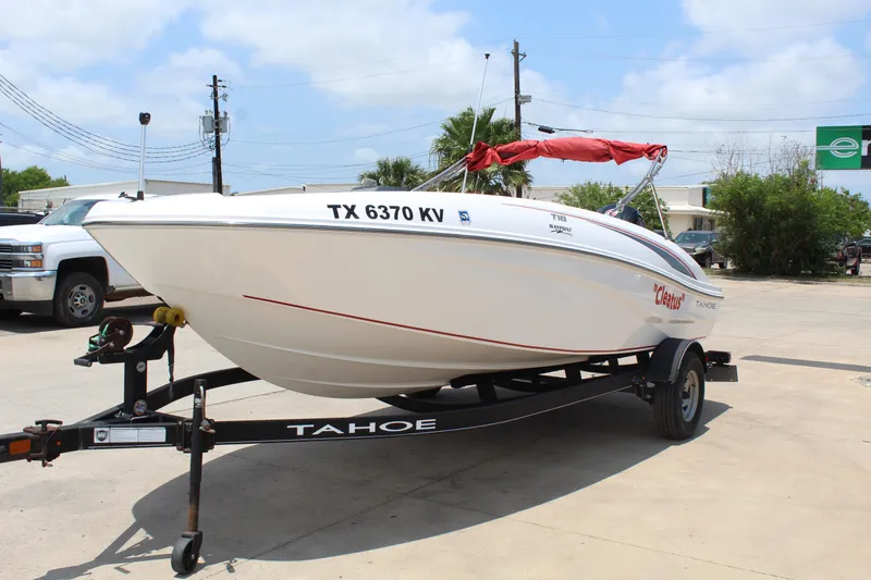 Slide: The Image of 2023 Tahoe T18 boat on trailer with red canopy, parked outdoors. - 3