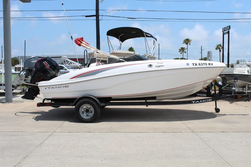 Slide: The Image of 2023 Tahoe T18 boat on trailer, parked outdoors under clear sky. - 4