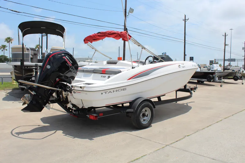 Slide: The Image of 2023 Tahoe T18 boat on trailer, parked outdoors, with outboard motor. - 5