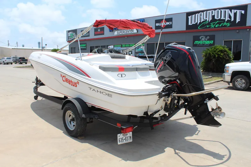 Slide: The Image of 2023 Tahoe T18 boat on trailer, parked outside dealership, with red canopy and outboard motor. - 7